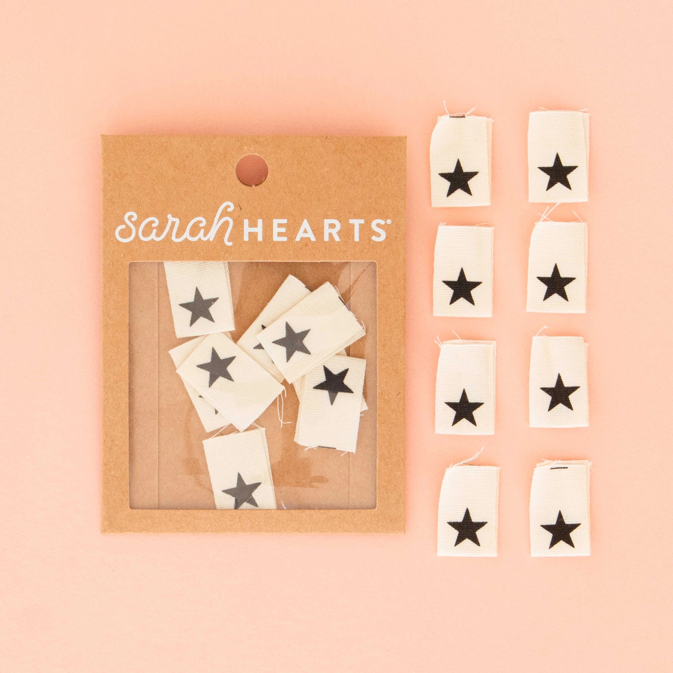 Packaged product with star-shaped stickers on a pink background, featuring the brand 'Sarah Hearts'.