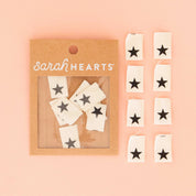 Packaged product with star-shaped stickers on a pink background, featuring the brand 'Sarah Hearts'.