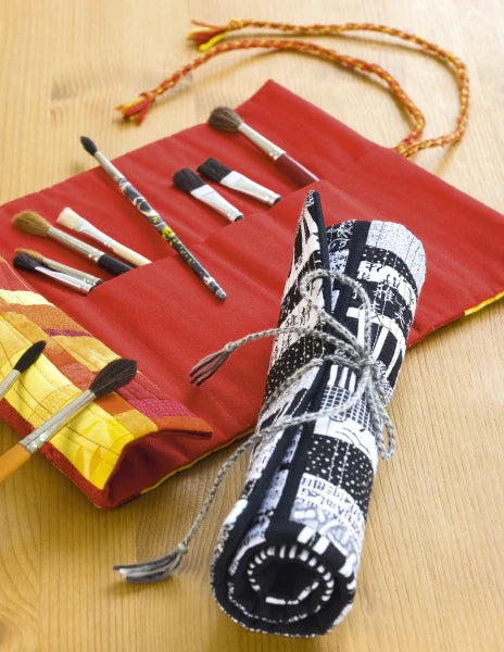 Set of makeup brushes in a decorative case on a wooden surface