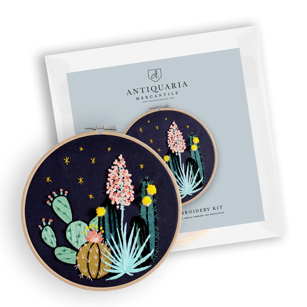 Embroidery hoops with cactus and flower designs on a white background, featuring Antiquaria Mercantile branding.