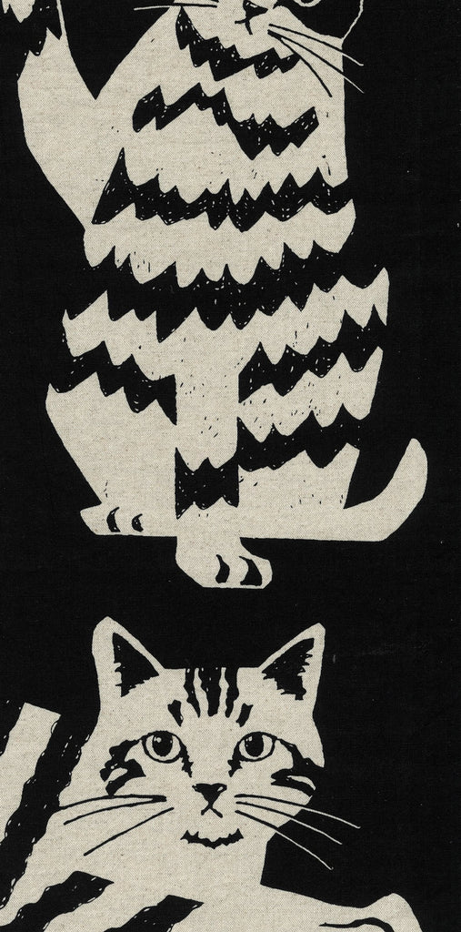 Black and white illustration of a cat with a stylized pattern on a black fabric