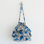 Blue and white patterned drawstring bag on a light gray background
