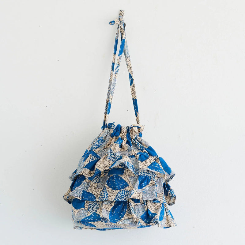 Blue and white patterned drawstring bag on a light gray background