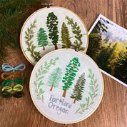 Embroidery hoops with tree designs and 'Portland Oregon' text on a wooden surface.