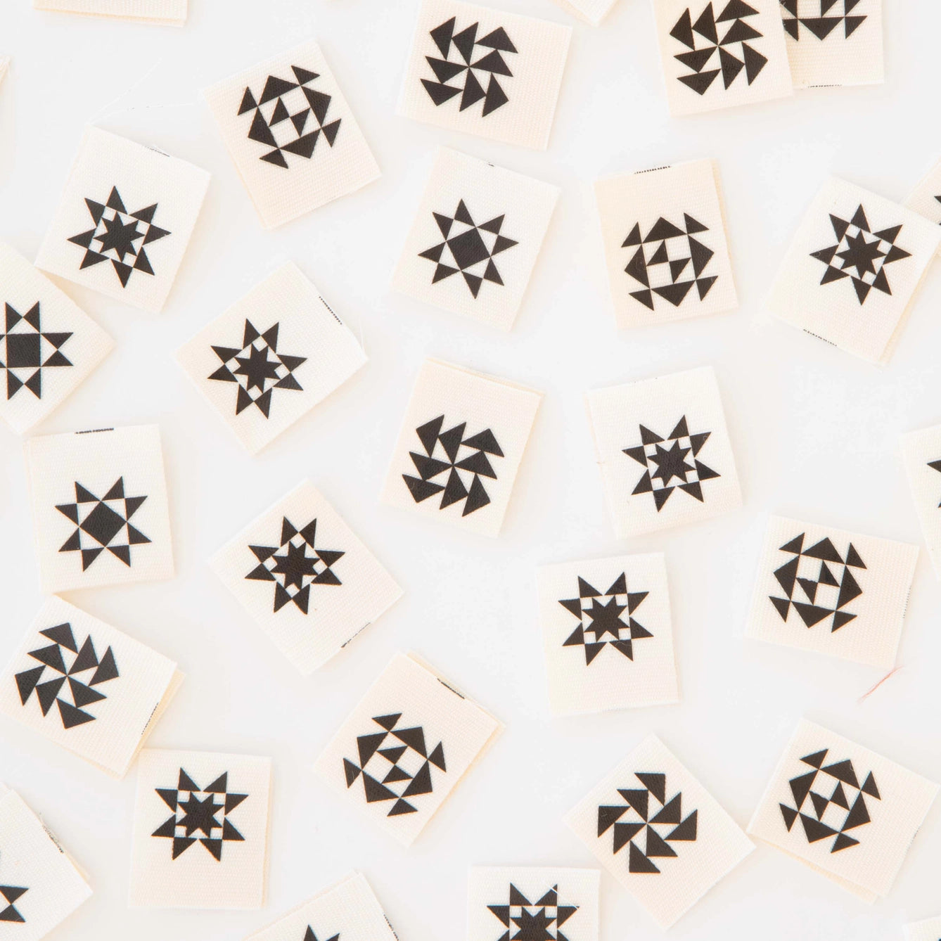 Pattern of black quilt shapes on beige tags