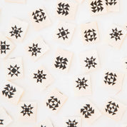 Pattern of black quilt shapes on beige tags