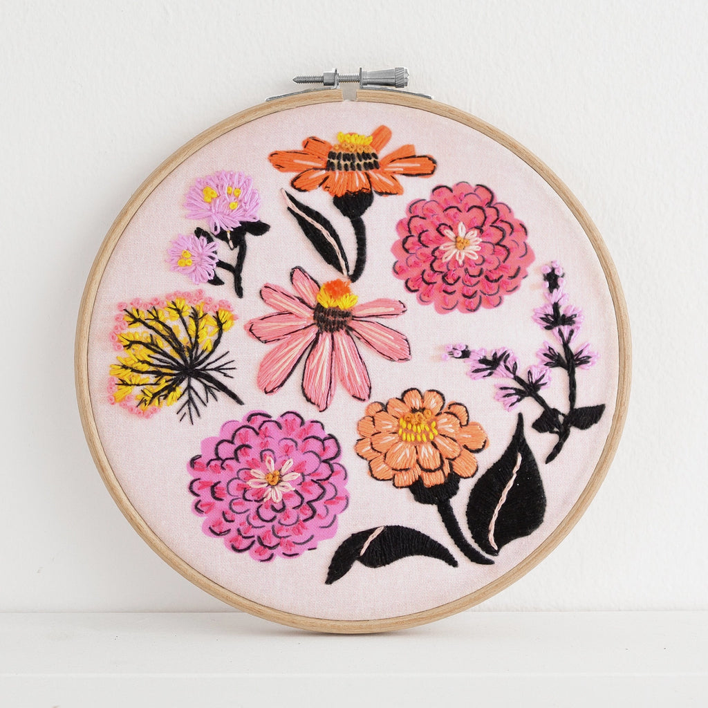 Embroidery hoop with colorful floral design on a white background