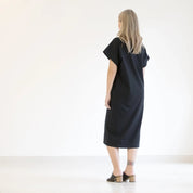 person wearing a black dress on a white background