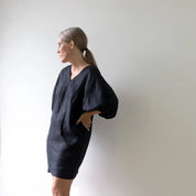 personwearing a black dress against a plain white background