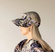 person wearing a floral visor against a neutral background