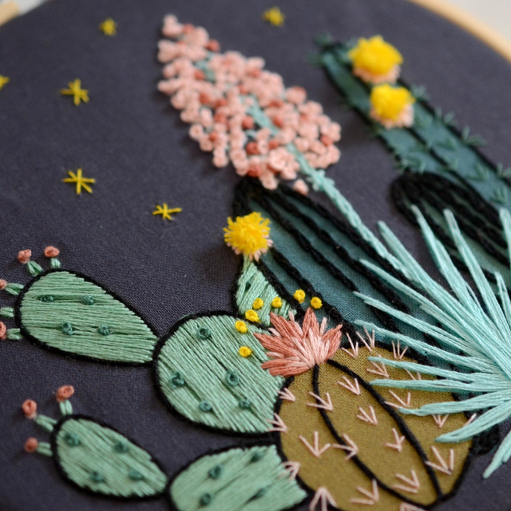 Embroidery of cacti and flowers on a dark background