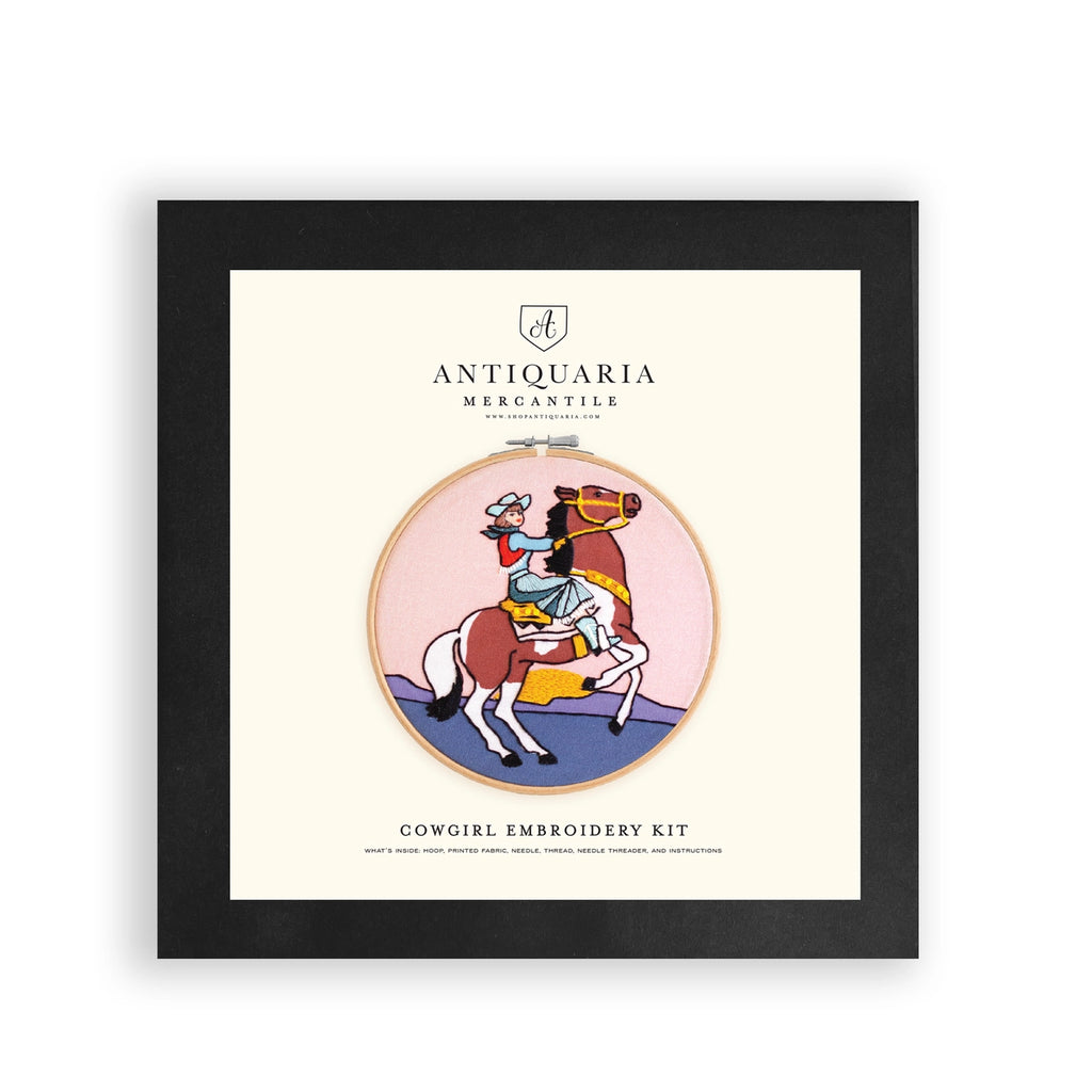 Framed Antiquaria Mercantile cowgirl embroidery kit packaging on a white background