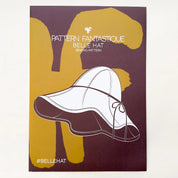 Sewing pattern cover for 'Pattern Fantastique Belle Hat' with a hat design on a purple and yellow background.