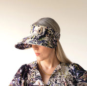 person wearing a floral visor and matching outfit against a plain background