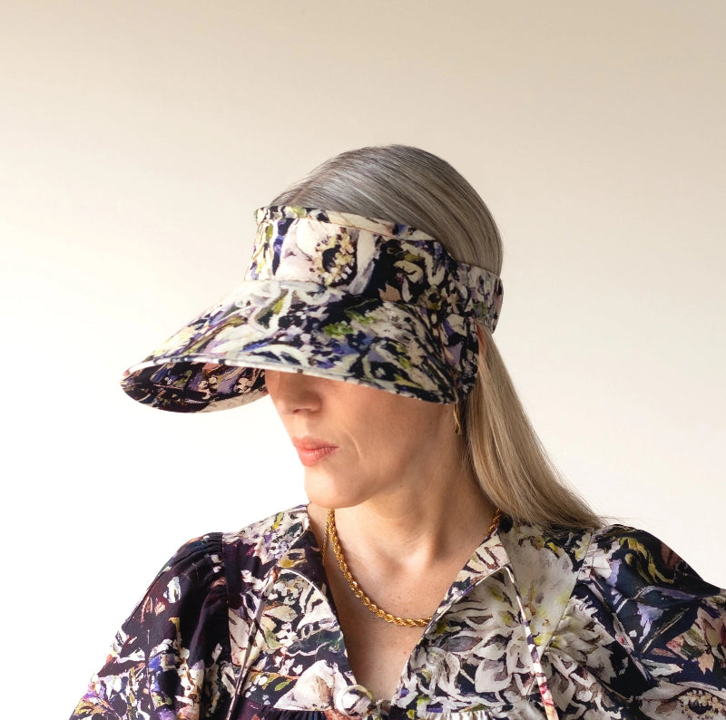person wearing a floral visor and matching outfit against a plain background