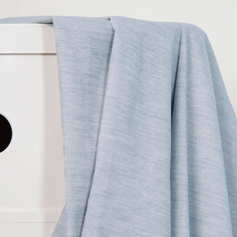 Light blue fabric draped over a white surface