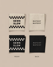 Two fabric labels with 'Sewn Slow' and 'Matchy Matchy' text on a beige background
