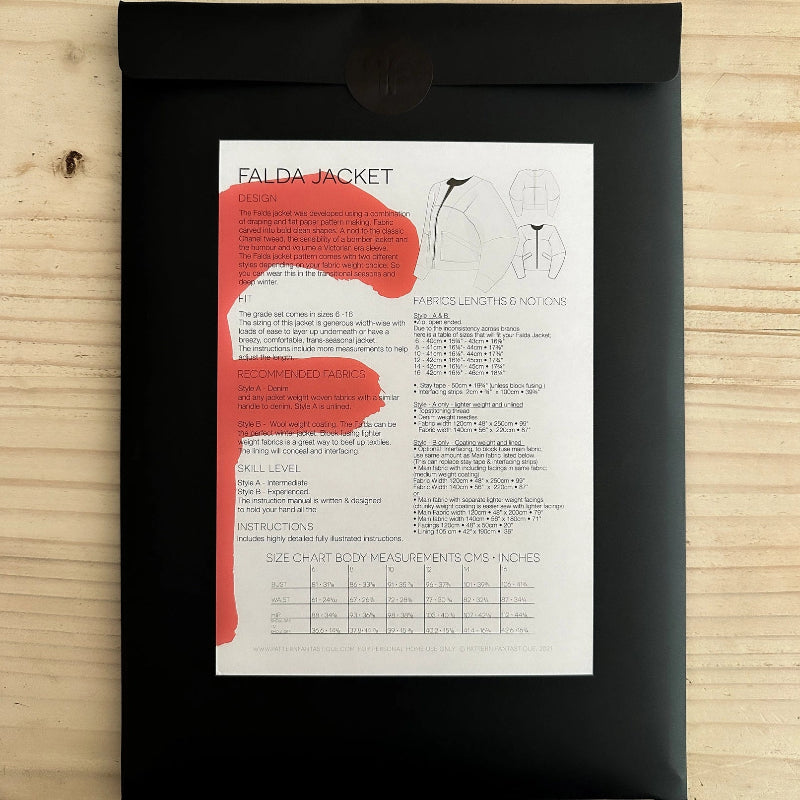 Black jacket packaging with a white label featuring text and graphics on a wooden surface