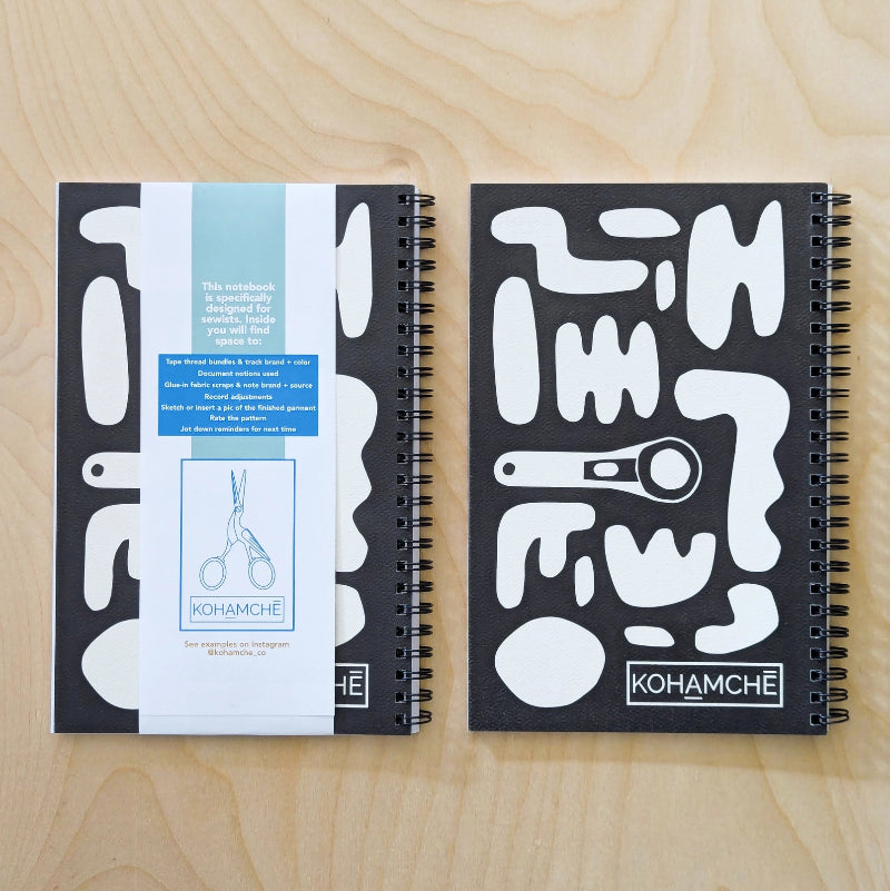Two notebooks with black and white designs on a wooden surface