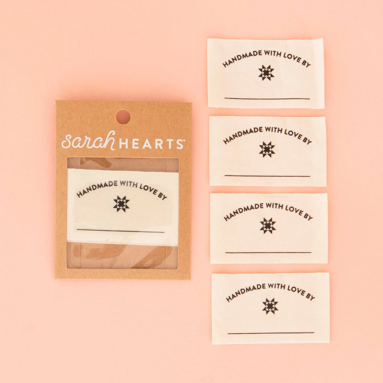 Packaging of 'Handmade with Love by Sarah Hearts' labels on a pink background