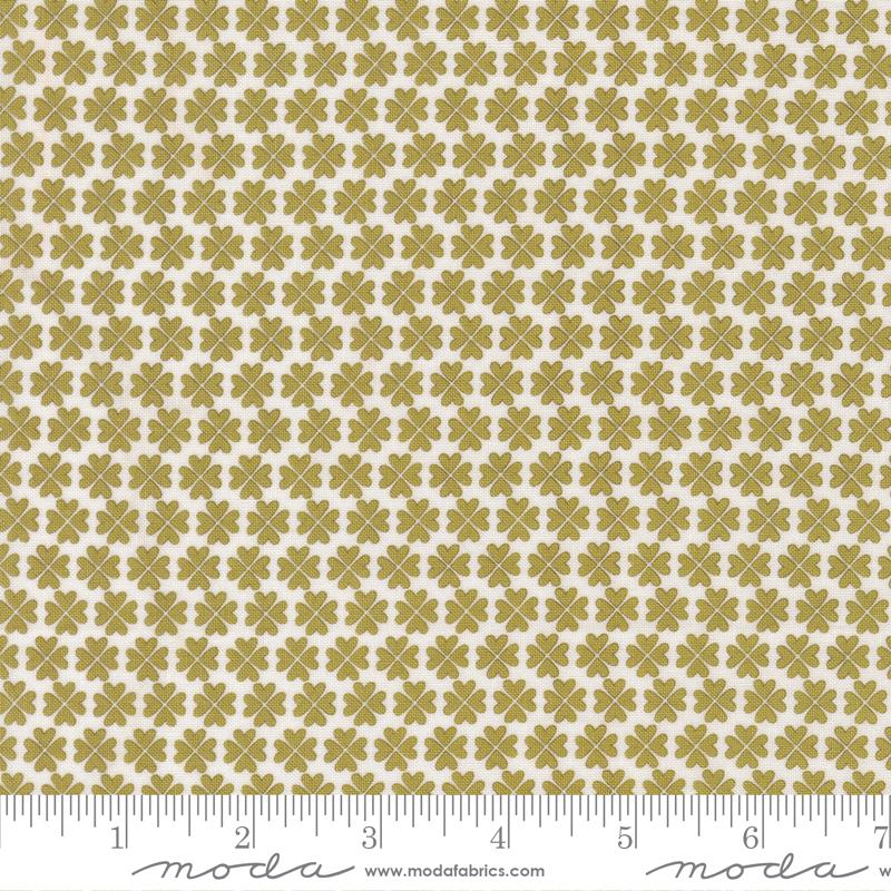 Fabric swatch with a green and beige pattern and Moda label.