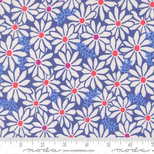 Fabric with blooming white flowers on a blue background with a ruler at the bottom for scale