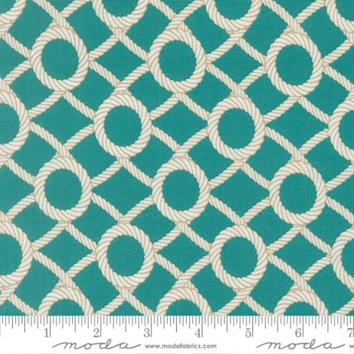 Fabric with nautical rope design on a blue background with a ruler at the bottom for scale