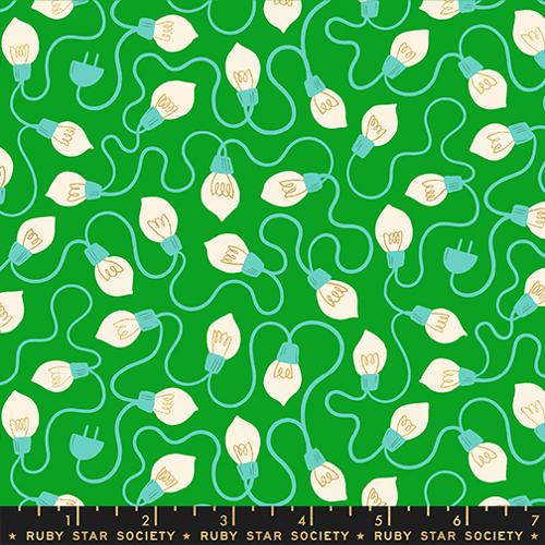 Fabric pattern of light bulbs and wires on a green background with a ruler at the bottom.