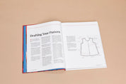 Open book on a beige background with sewing pattern instructions and diagram.