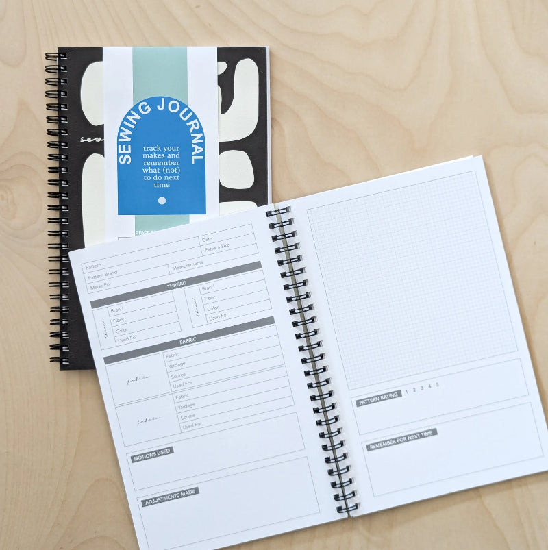 Sewing journal with open pages on a wooden surface