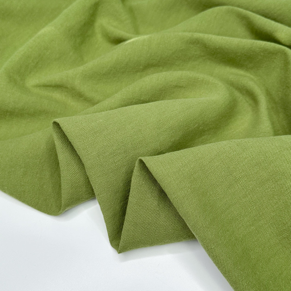 Wrinkled olive green linen fabric on a plain background.