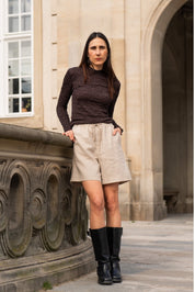 Person standing outdoors in front of a stone building