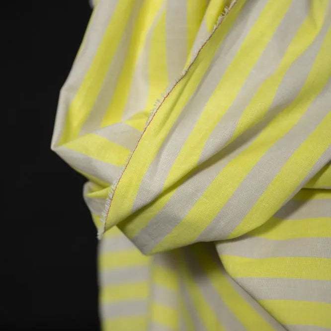 Close-up of a yellow and white striped fabric with a dark background