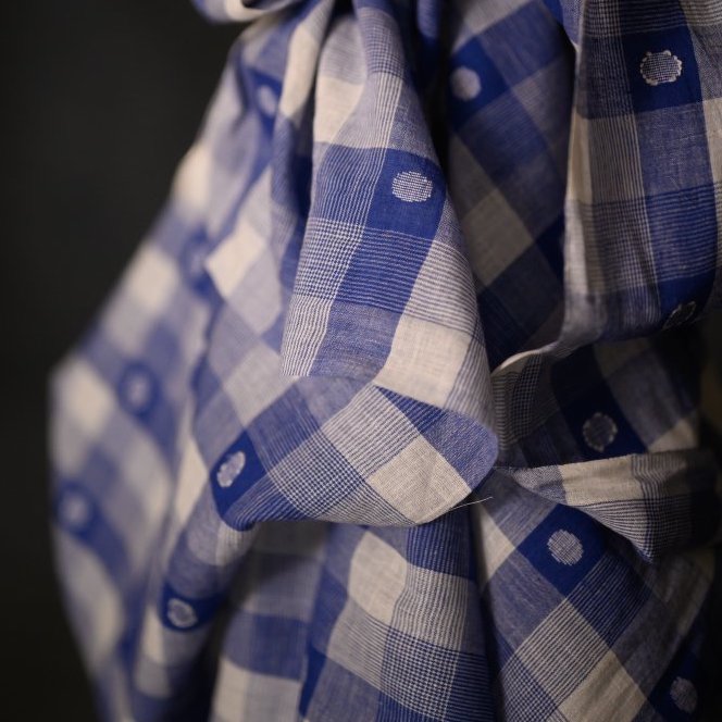 Close-up of blue and white checkered fabric with a dark background