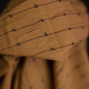 Loopy fabric Close-up of a brown fabric with black thread patterns