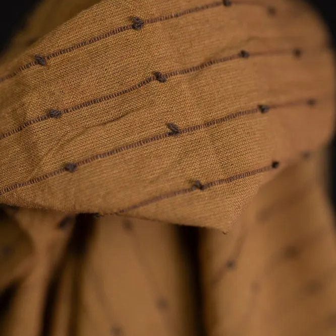 Loopy fabric Close-up of a brown fabric with black thread patterns