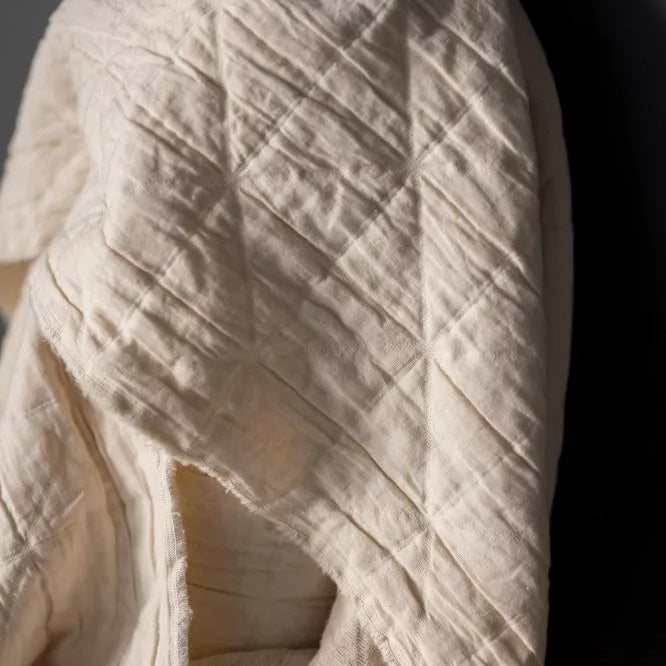 Close-up of a textured beige fabric against a dark background