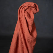 Reddish-brown fabric draped over a black background