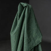 Dark green fabric with small white dots on a dark background