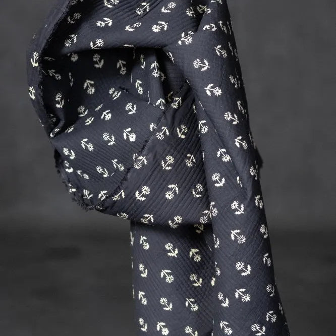 black quilted fabric white floral pattern on a dark gray background