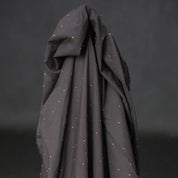 Dark gray fabric with small colorful dots on a black background