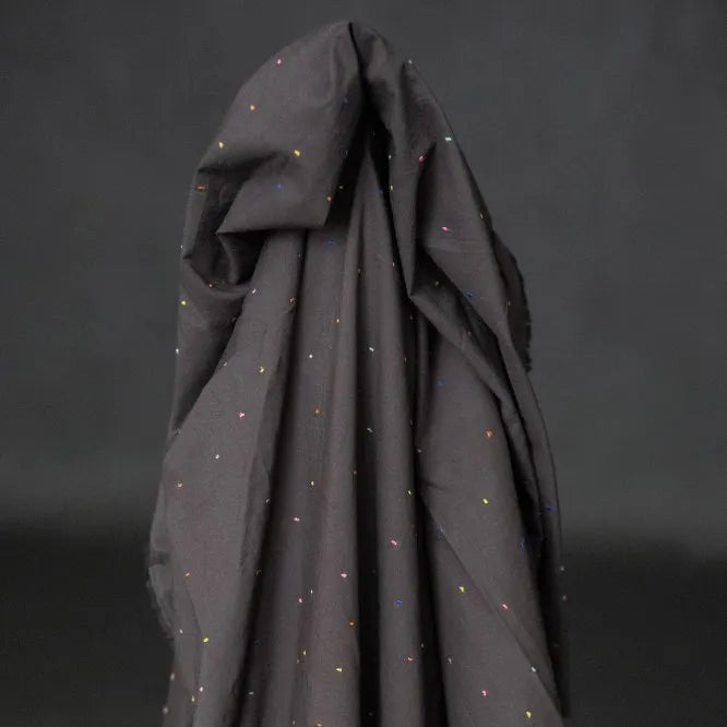 Dark gray fabric with small colorful dots on a black background
