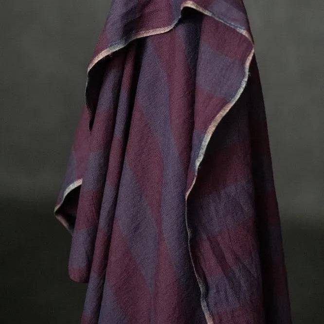 Purple textured fabric draped over a neutral background