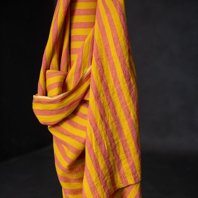Yellow and red striped linen fabric draped over a black background