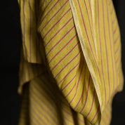 Yellow and red striped fabric draped over a black background