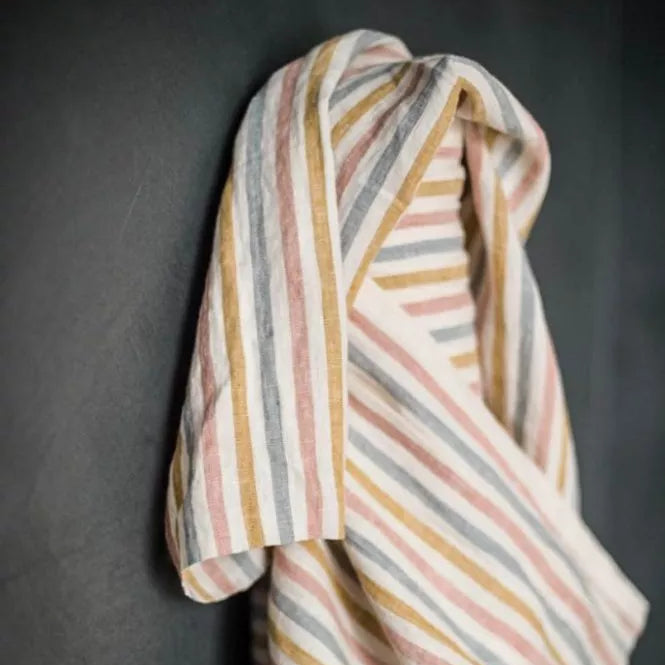 Striped fabric with multicolor pattern draped over a dark surface