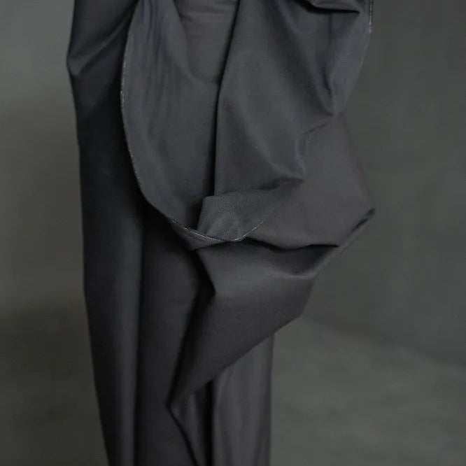 Merchant & Mills black fabric draped over a form against a dark background