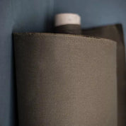 Roll of olive oilskin fabric on a dark background