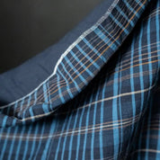 Close-up of blue plaid fabric with a dark background