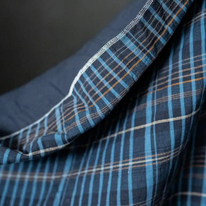 Close-up of blue plaid fabric with a dark background